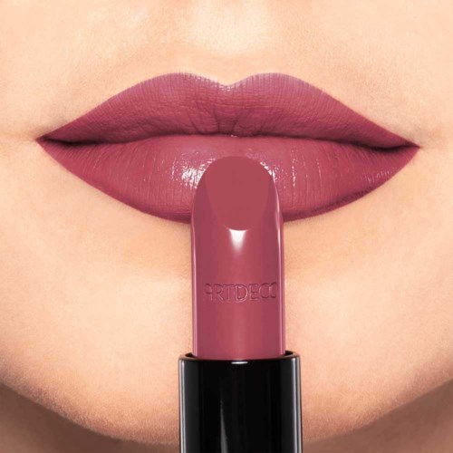Nahaufnahme von Lippen mit rosa Lippenstift und passendem Lippenstiftstift.