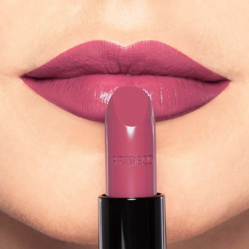 Nahaufnahme von Lippen mit rosa Lippenstift, mit einem passenden Lippenstift darunter.