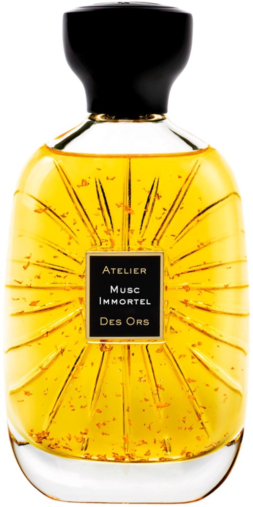 A perfume bottle with gold liquid, black cap, and a label reading "Atelier Musc Immortel Des Ors".