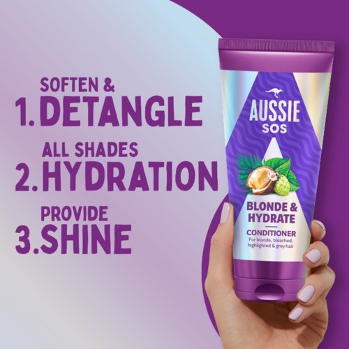 A hand holds a purple bottle of Aussie hair conditioner, with text highlighting benefits like detangling, hydration, and shine.