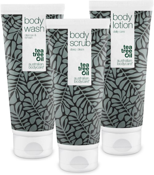 Three tubes of body care products with leaf patterns, labeled as body wash, body scrub, and body lotion, with tea tree oil.