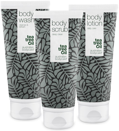 Drie lichaamsverzorgingsproducten: body wash, scrub en lotion met tea tree olie, met bladpatroon in grijs en wit.