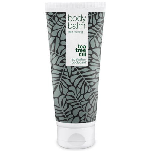 Eine Tube Body Balm mit grünem und schwarzem Blättermuster, beschriftet 'body balm after shaving tea tree oil'.