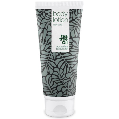 Eine Tube mit Bodylotion mit Blättermuster und Etiketten für Teebaumöl und tägliche Pflege.