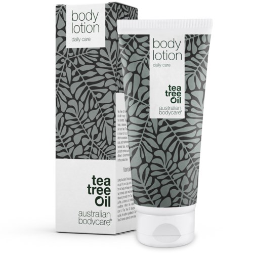 Eine Tube und eine Schachtel Bodylotion mit Blattmuster, gekennzeichnet als Teebaumöl für tägliche Pflege.