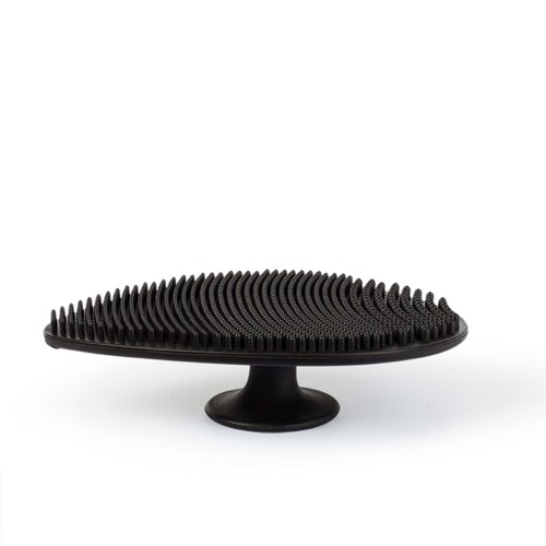 Een zwarte siliconen hoofdhuidmassager met veel kleine spikes, rust op een witte achtergrond.