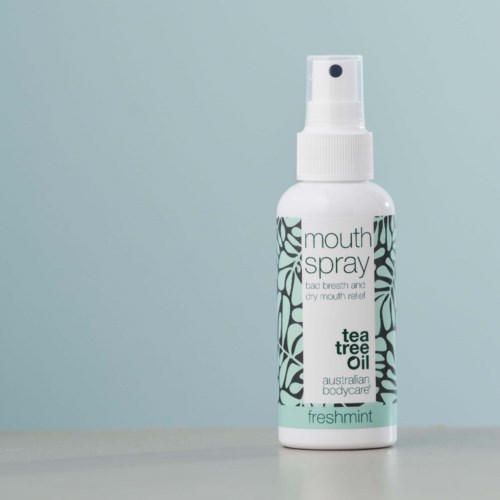 Eine kleine weiße Sprühflasche mit 'mouth spray' Beschriftung, enthält Teebaumöl und Minze, für frischen Atem.