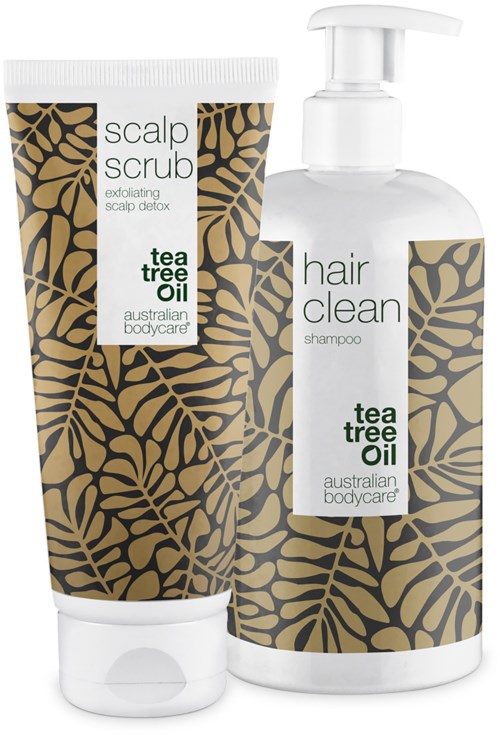 Zwei Haarpflegeprodukte: ein Peeling und ein Shampoo, beide mit Teebaumöl, in Flaschen mit Blattmustern.