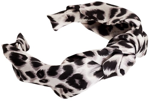 A headband with a black and white animal print, twisted in the middle, against a black and white background.