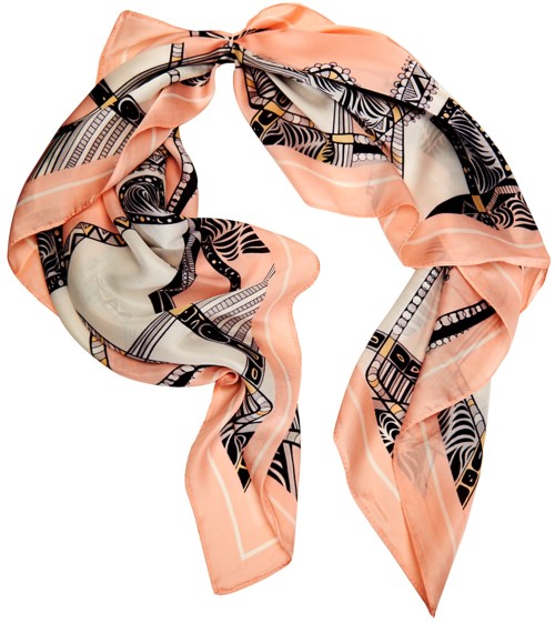 En aprikosfärgad siden scarf med svarta och vita tribalmönster, knuten i en lös knut, faller mjukt.