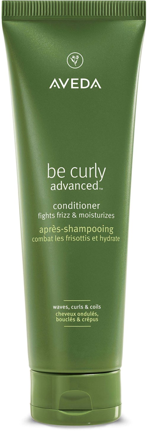Eine grüne Tube Aveda Be Curly Conditioner, die gegen Frizz kämpft und lockiges Haar mit Feuchtigkeit versorgt.