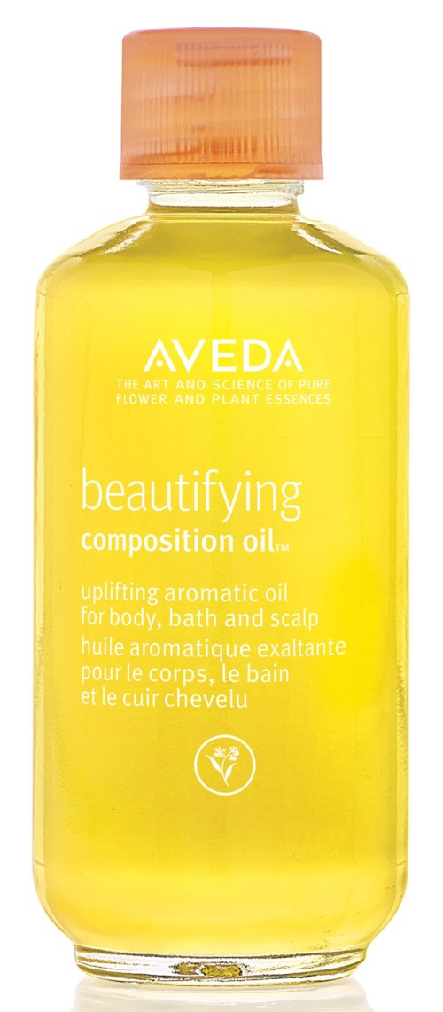 Eine gelbe Flasche mit rosa Deckel, beschriftet 'Aveda beautifying composition oil' für Körper und Kopfhaut.