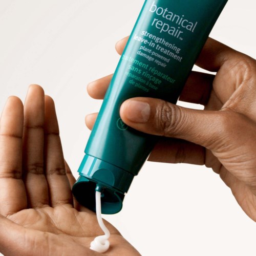 Eine Person drückt auf eine Tube mit der Aufschrift botanical repair und gibt Creme auf die Hand.