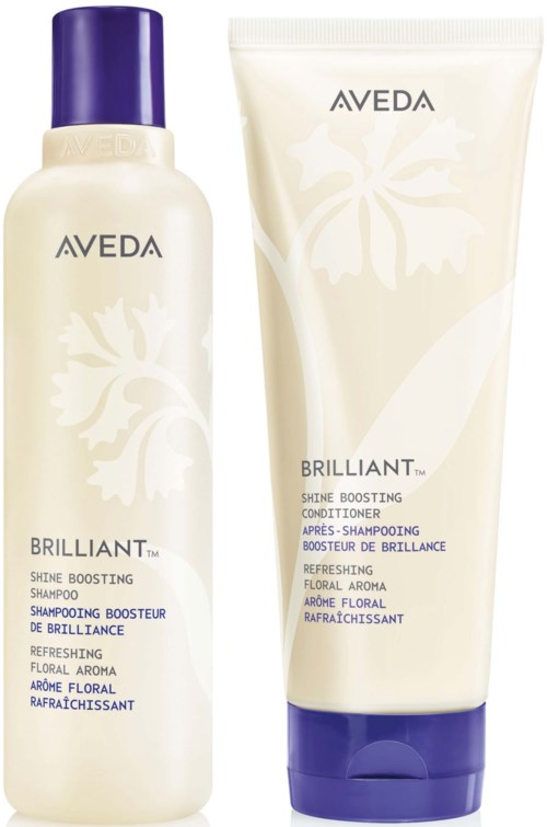 En flaske og en tube med Aveda Brilliant Shine Boosting Shampoo og Conditioner med floral design på emballasjen.