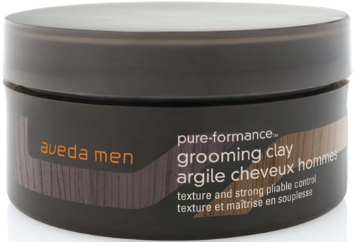 Ein Behälter Aveda Men pure-performance grooming clay mit schwarzem und grauem Etikett, orange Text und lila Streifen.