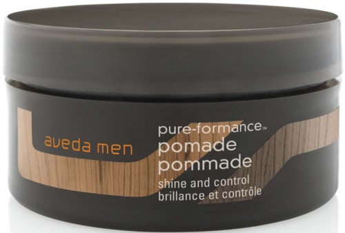 Ein schwarzer Behälter mit braun und orangeem Design, Etikett sagt Aveda Men pure performance pomade, für Glanz und Kontrolle.