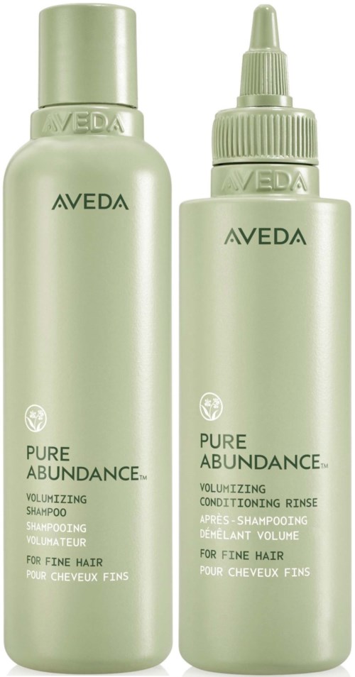 Zwei grüne Flaschen mit Aveda Pure Abundance Haarprodukten, Shampoo und Conditioner, für feines Haar.