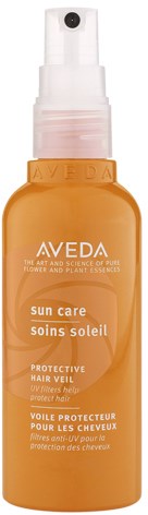 A small spray bottle labeled Aveda Sun Care, orange and white, for protecting hair from sun damage.