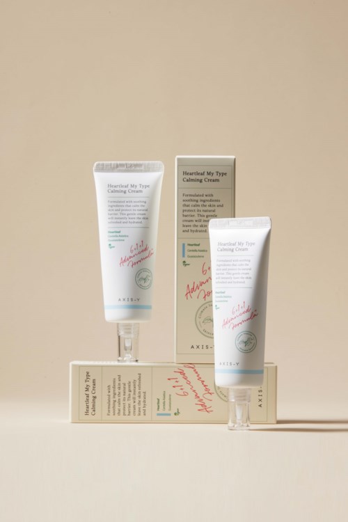 Een huidverzorgingstube en doos staan op een beige achtergrond, gemarkeerd 'Heartful My Type Calming Cream.'