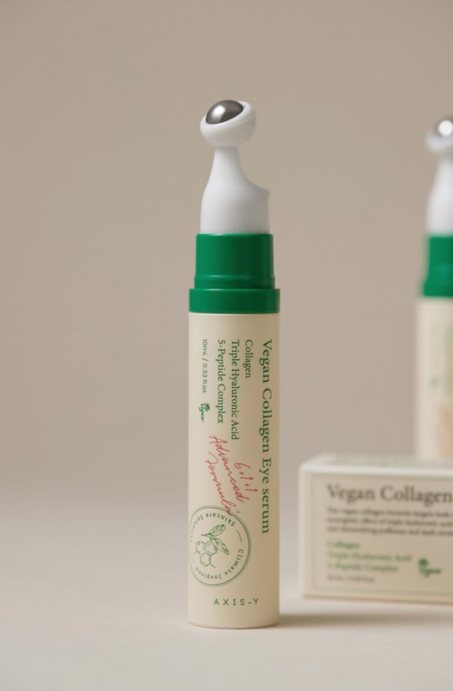 Een huidroller met een kleine, bonkige roller bovenop, groene en witte verpakking, met tekst op het label.