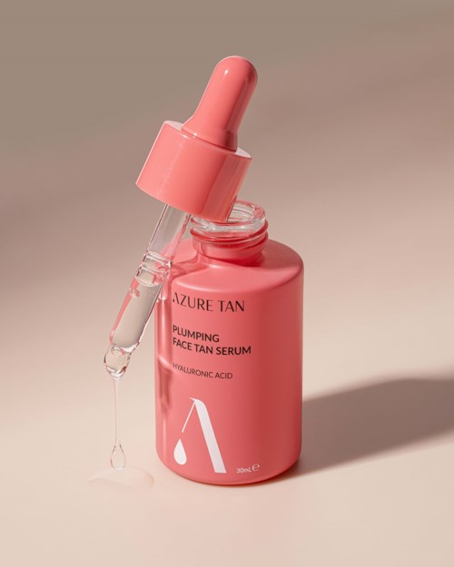 Rosa Flasche mit Pipette, als Gesichtssonne-Serum gekennzeichnet, enthält Hyaluronsäure. Ein Tropfen hängt an der Pipette.
