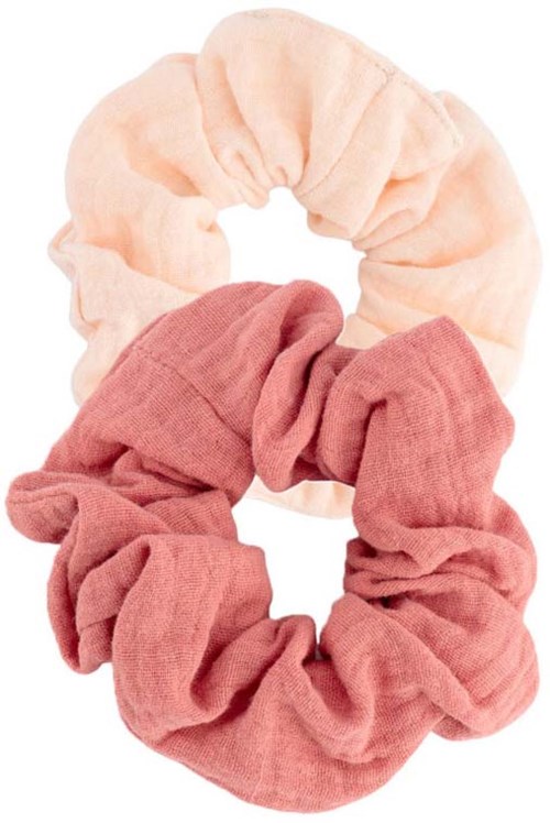 Two fabric hair scrunchies, one light peach and one pink, are stacked and intertwined.