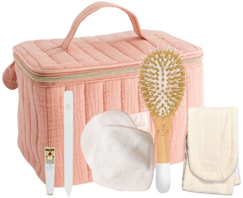 A soft pink toiletry bag with a handle, containing a hairbrush, a white cloth, a disposable razor, and a folded cloth.
