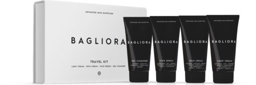 Biała pudełko z napisem 'Travel Kit' z pięcioma czarnymi tubkami produktów do pielęgnacji skóry obok.