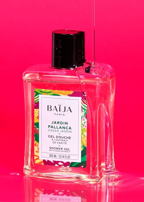 Bright pink background with a clear shower gel bottle labeled 'Jardin Pallanca, Cassis Jasmine,' standing upright.