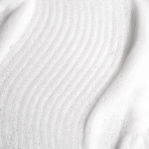 Close-up van witte getextureerde schuim met gladde krommen en kleine poriën.