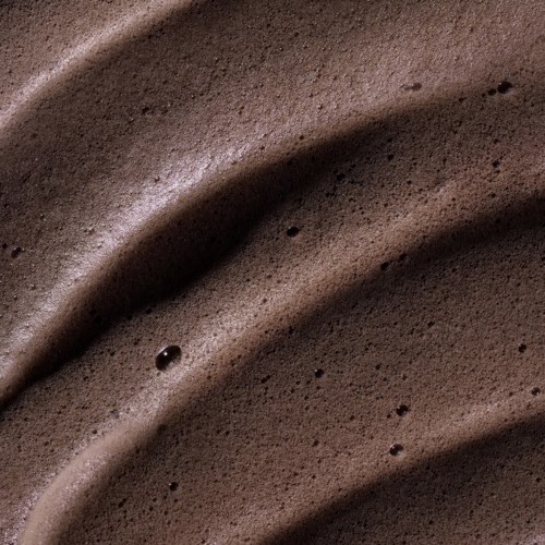 Close-up van chocolade schuim met gladde, gekromde texturen en kleine belletjes.
