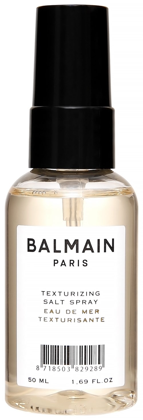 A small clear spray bottle with a black cap, labeled 'BALMAIN PARIS Texturizing Salt Spray.'