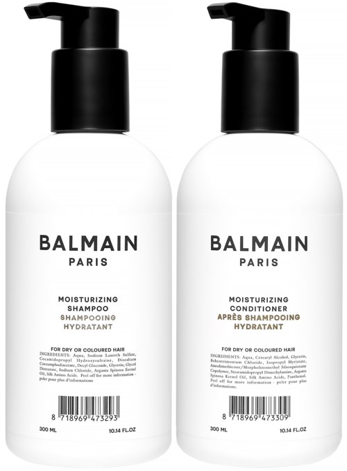 Kaksi valkoista Balmain Paris -pullot, joissa on mustat pumppukannet, yksi shampoo ja toinen hoitoaine.