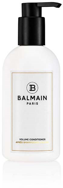 Valkoinen pullo Balmain Paris -volyymisampoolla ja mustalla annostelijalla, etikettiä koristelee musta ja kulta.