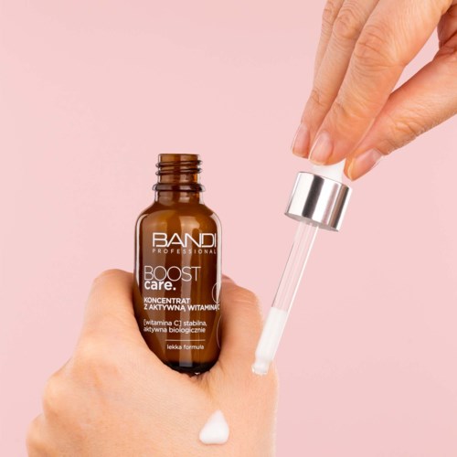 En hand håller en brun flaska märkt 'BANDI PROFESSIONAL BOOST care' och en annan hand tar bort ett silverlock, visar en dropper.