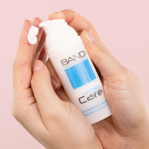 A person dispenses a white cream from a small bottle labeled 'Hydro Core'.