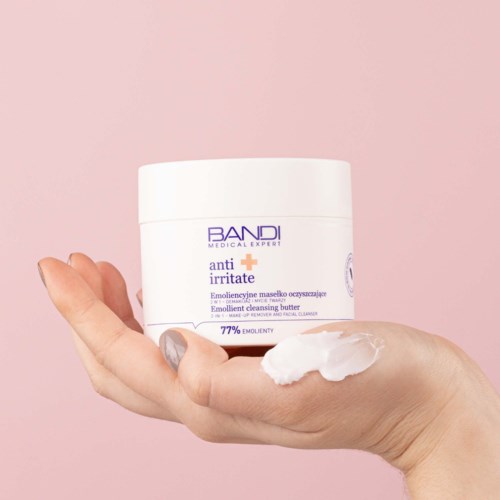 A hand holds a white jar labeled 'anti irritate' with a pink background.