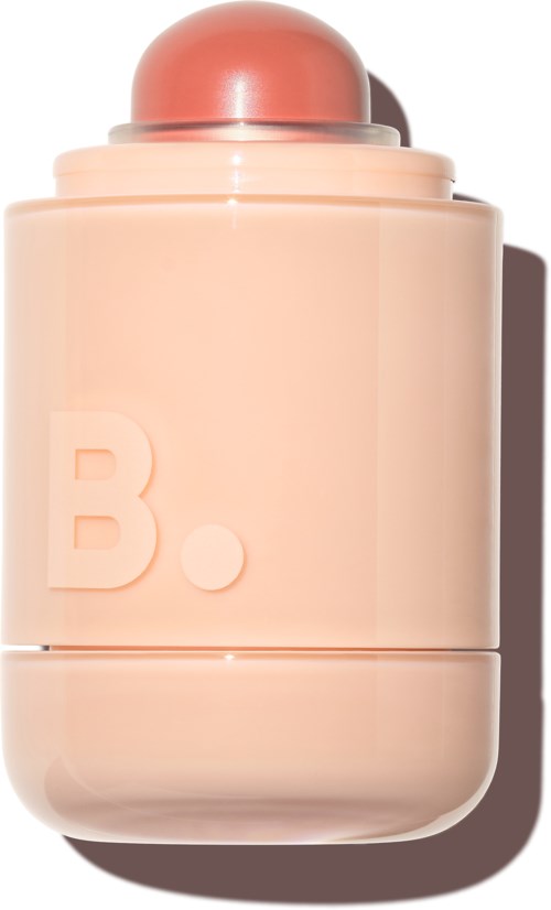 A pale pink perfume bottle with a round cap and a large letter B embossed on it.