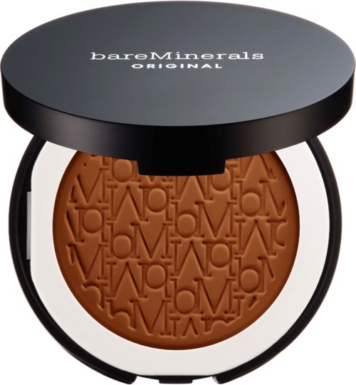 A round makeup mirror with a brown pressed powder inside, featuring an embossed design and supported by three black legs.