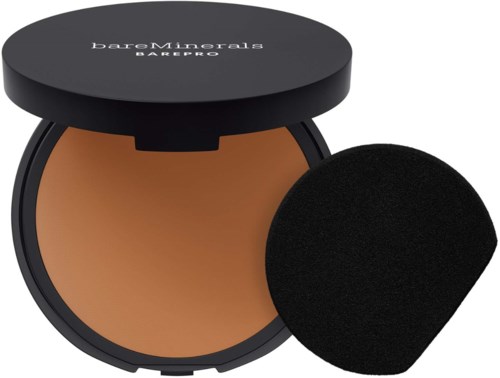 A compact powder container with a black lid, containing beige powder and a black applicator sponge.