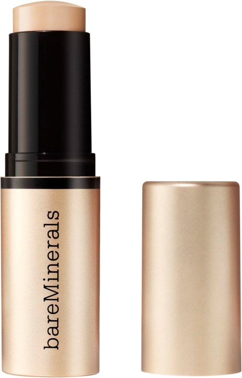 En beige kräm eller foundationstift med svart och gyllene lock, märkt bareMinerals.