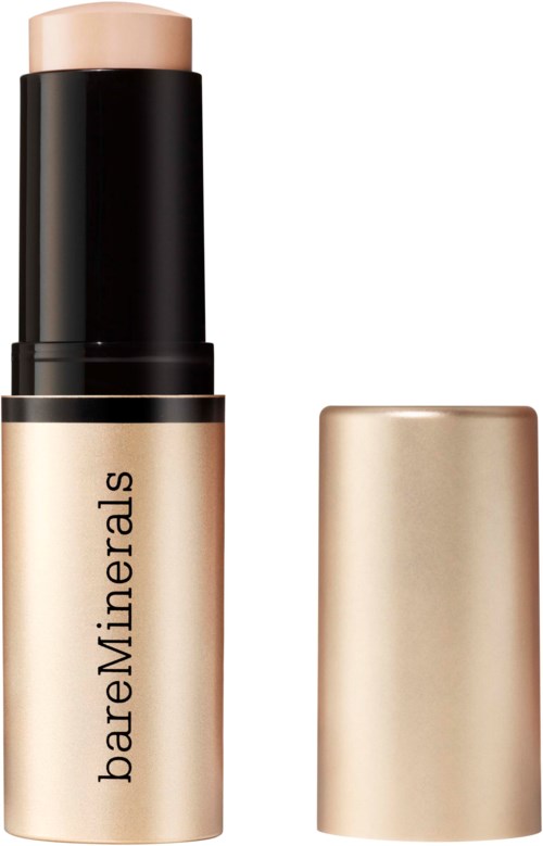 En beige foundationsstift med svart lock, märkt BareMinerals, och locket avlägsnat för att visa stiften.