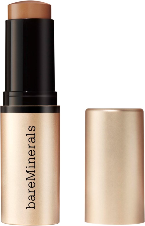 En beige foundationpinne med svart och guld förpackning märkt bareMinerals.
