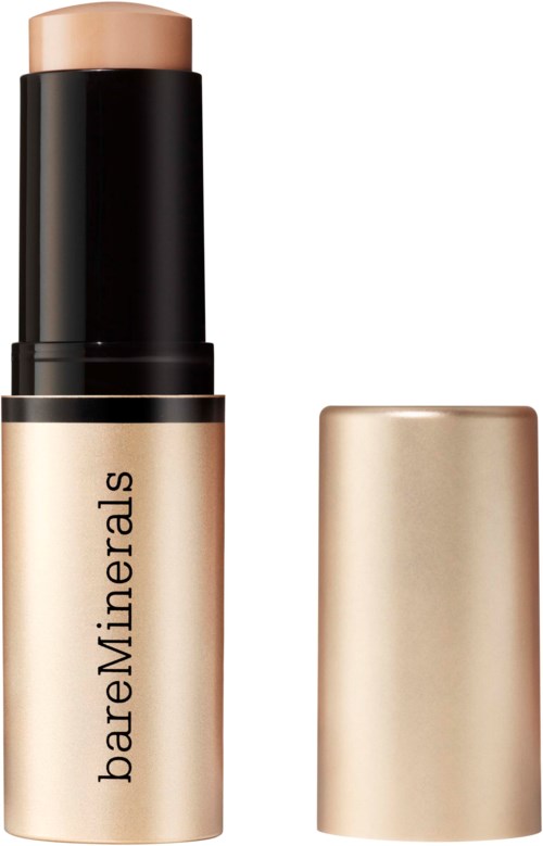 En beige makeup-pinne från bareMinerals med svart lock och guldbas, märket synligt på tuben.