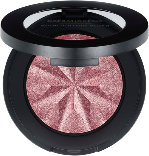 A pink highlighter blush with a star-shaped pattern in a black round compact. It has a mirror on the lid.