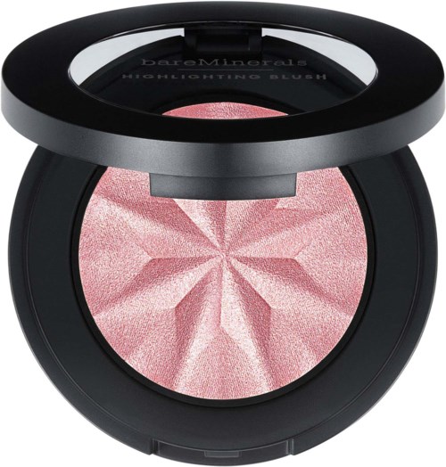 A pink highlighting blush with a star pattern inside a black compact case and a mirror on top.