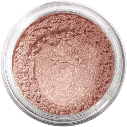 En rund behållare fylld med ljusrosa pulver, troligtvis makeup eller rouge, med en lite texturerad yta.