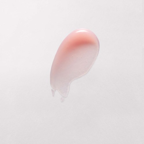 A clear gel with a pinkish tint is on a plain white surface, shaped like a drop.