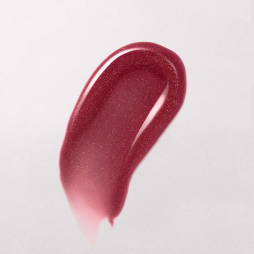 A red, shiny, teardrop-shaped gel or nail polish drop on a white background.