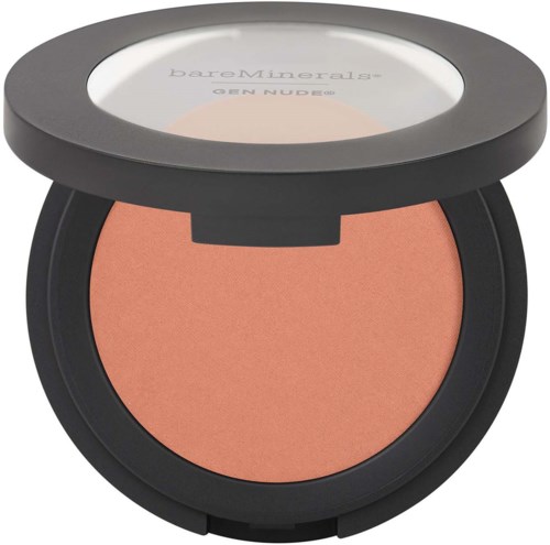 A compact of peach-colored blush with a black lid and a clear window showing the makeup inside.